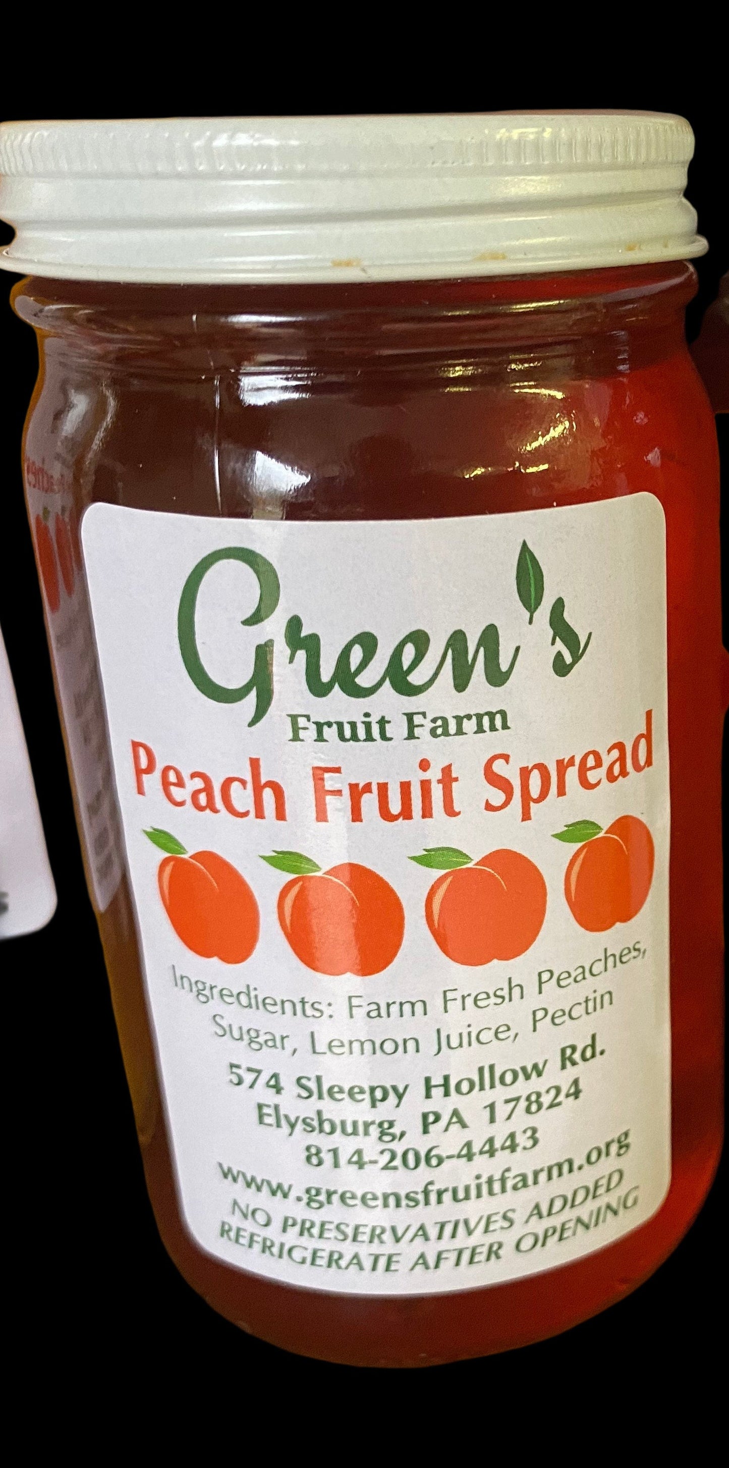Two jars of Green's Peach Fruit Spread on a wooden surface